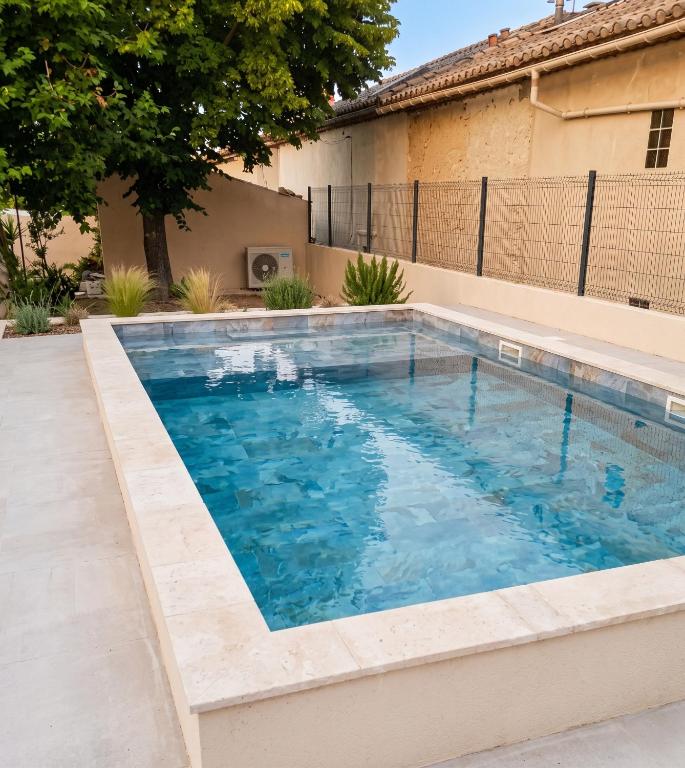 a swimming pool with blue water in a backyard at Maison à Vedène avec piscine privée in Vedène