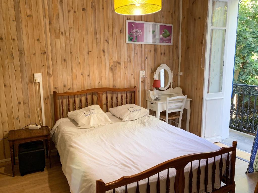 a bedroom with a bed and a table and a mirror at Appartement cosy à Néris-les-Bains, 20 m², balcon avec vue in Néris-les-Bains