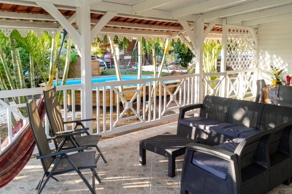 a porch with chairs and a gazebo at Appartement spacieux au Vauclin avec piscine privée in Le Vauclin