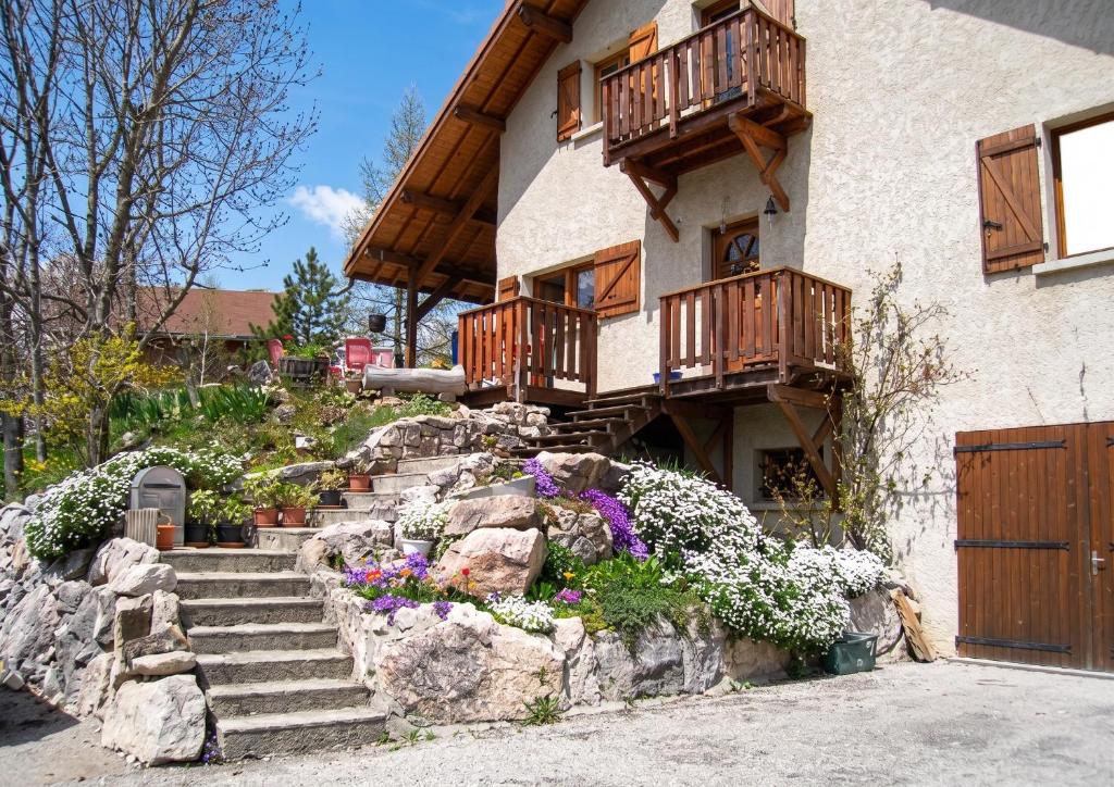 a house with wooden balconies and flowers in front of it at Appartement chaleureux à Gresse-en-Vercors 43 m² vue montagne in Gresse-en-Vercors