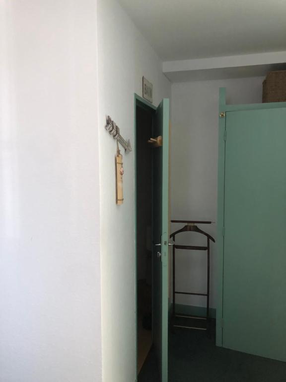 a hallway with an open door and a room with a door at Chambre la paix verte in Payrac
