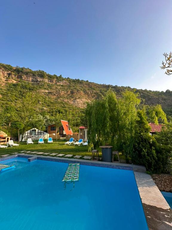 a swimming pool with a mountain in the background at arida farm peach in Bcharré