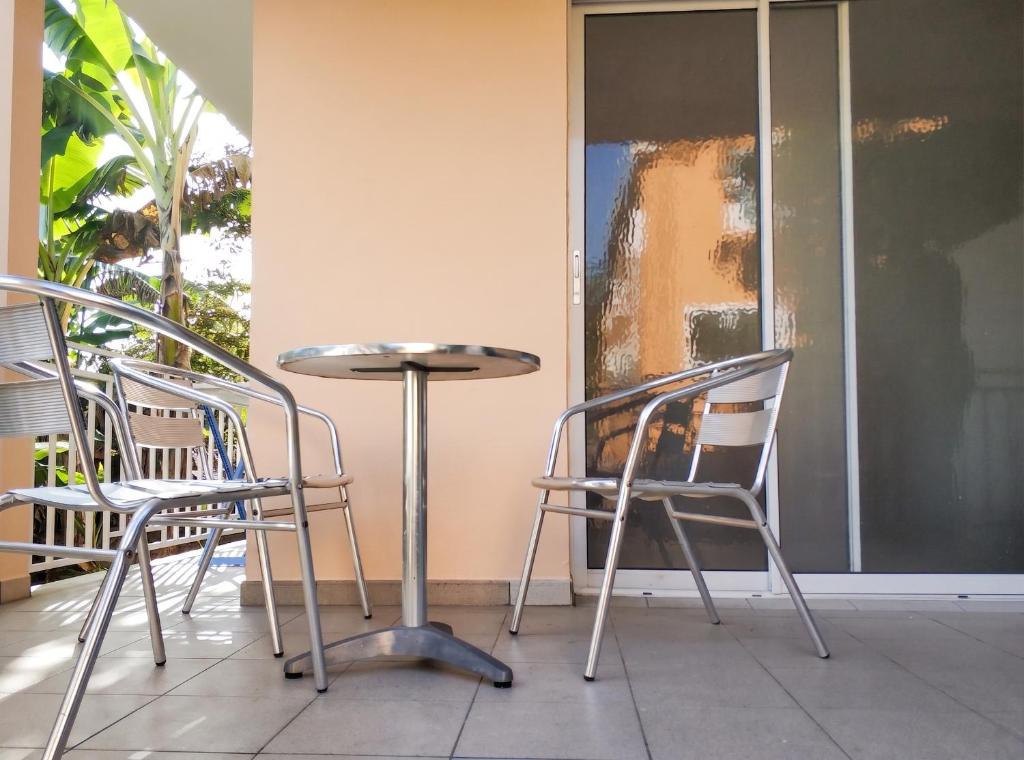 two chairs and a table on a porch at Appartement charmant au Lamentin avec terrasse et jardin, 46 m² in Le Lamentin