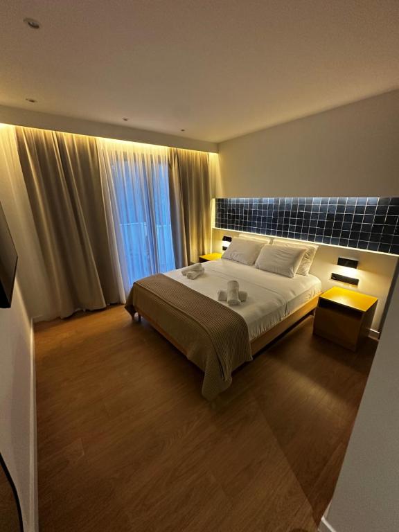 ein Schlafzimmer mit einem großen Bett und einem großen Fenster in der Unterkunft Aetheria resort in Samothráki