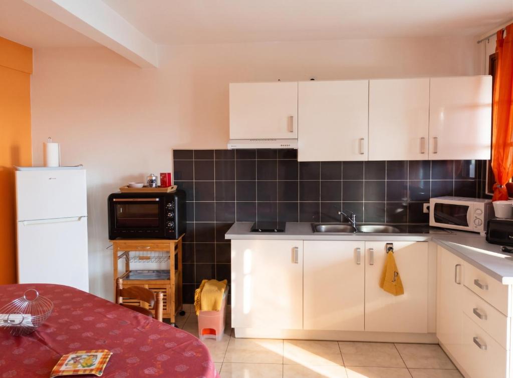 a kitchen with white cabinets and a sink at Appartement moderne avec vue mer à Bouillante, 50 m² in Bouillante