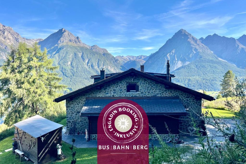 a sign in front of a building with mountains in the background at Bergchalet Flöna in Scuol