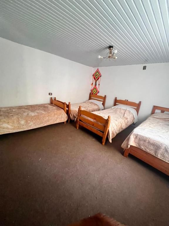 a room with three beds and a ceiling at Bjeshket e Thethit Hostel in Theth