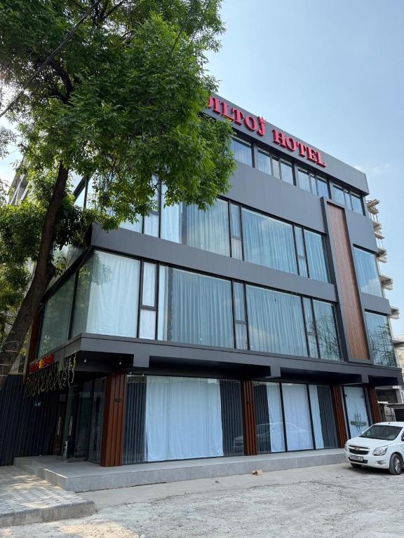 a building with a car parked in front of it at Diltoj Hotel Tashkent in Tashkent