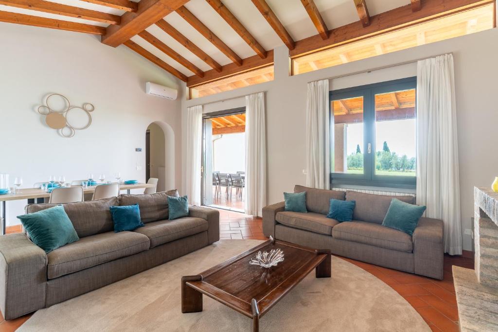 a living room with two couches and a table at Villa Selva in Manerba del Garda