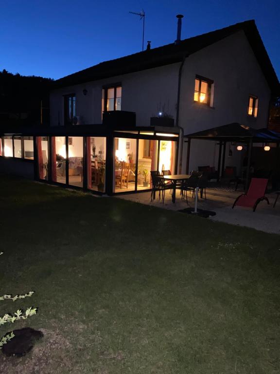 a house with glass doors and a table in front of it at Chez Nanou in Marmagne