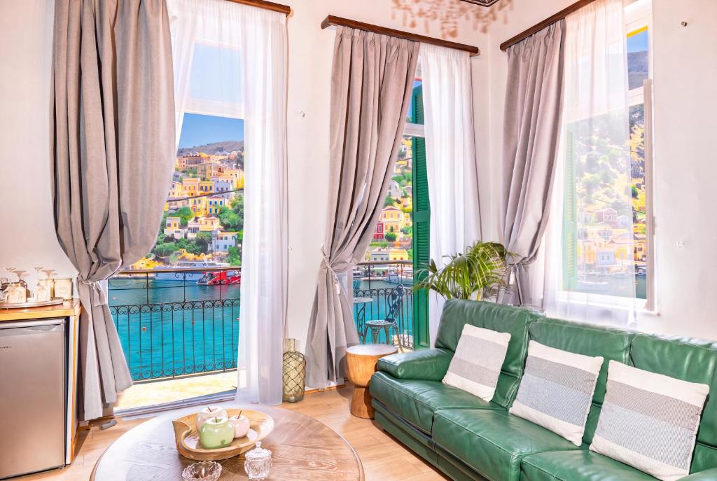 a living room with a green couch and large windows at "LOS" 2 Neoclassic Harbour View in Symi