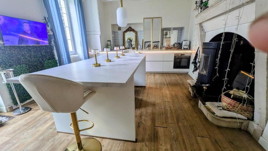 a kitchen with a white counter and a fireplace at L'héritage in Champdeniers