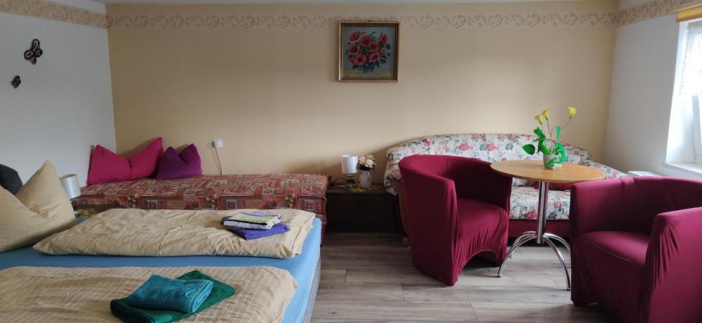 a living room with a couch and a table and chairs at Pension Pencik in Kurort Altenberg