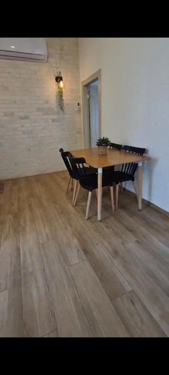 a table and chairs in a room with a wooden floor at בצלי-ה in Safed