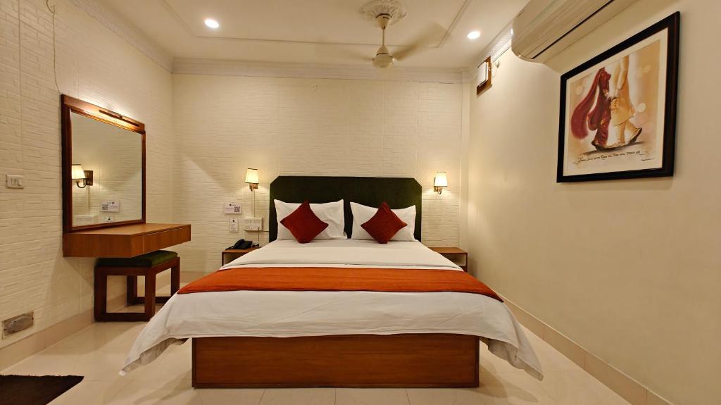 a hotel room with a bed and a desk at Hotel Saluja in Siliguri