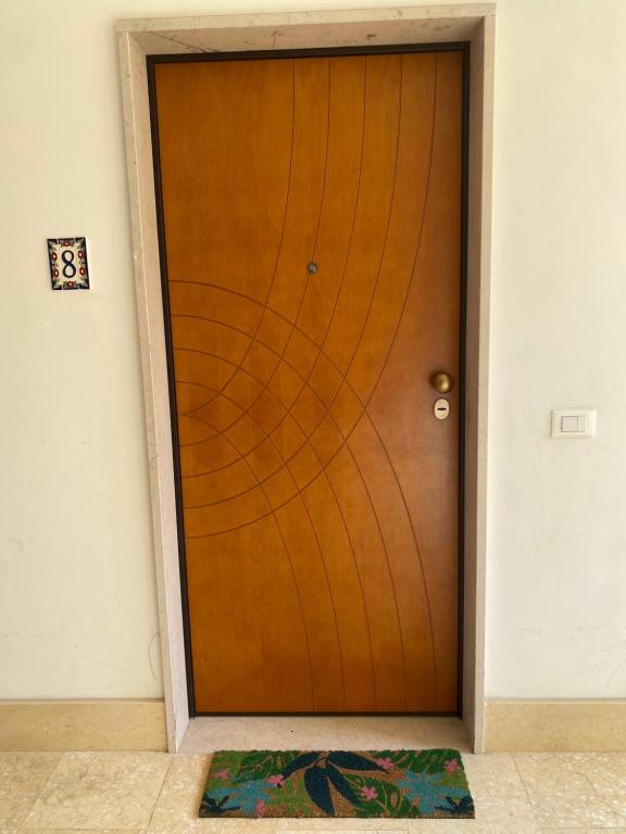 a wooden door with a mat in front of it at Gioia Casa in Pizzo