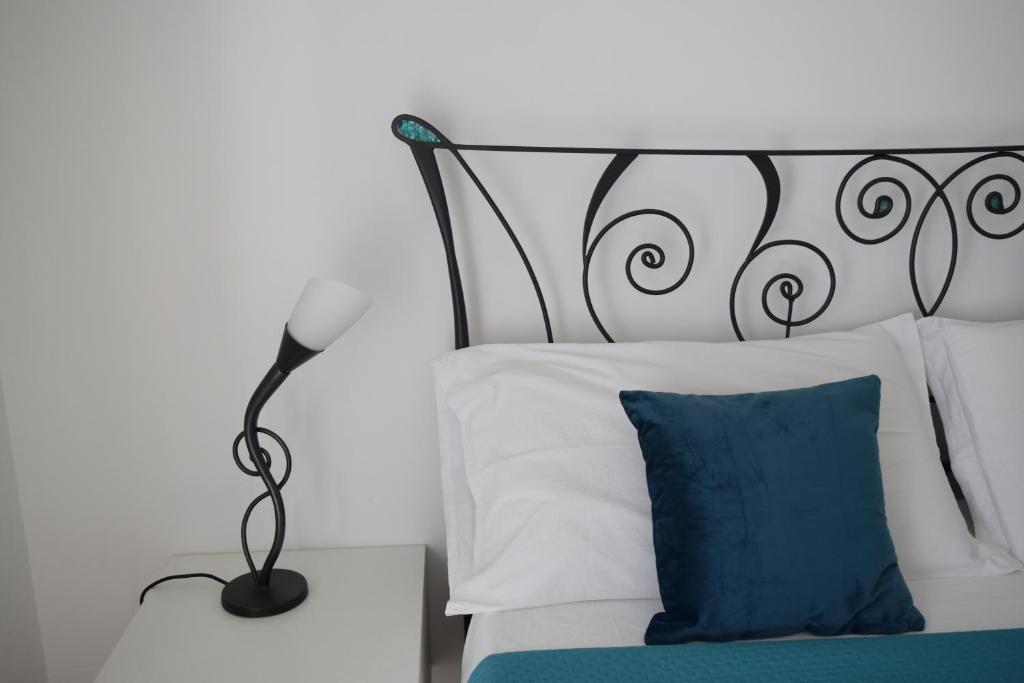a bed with a black lamp and a blue pillow at Il rifugio magico in Valmontone