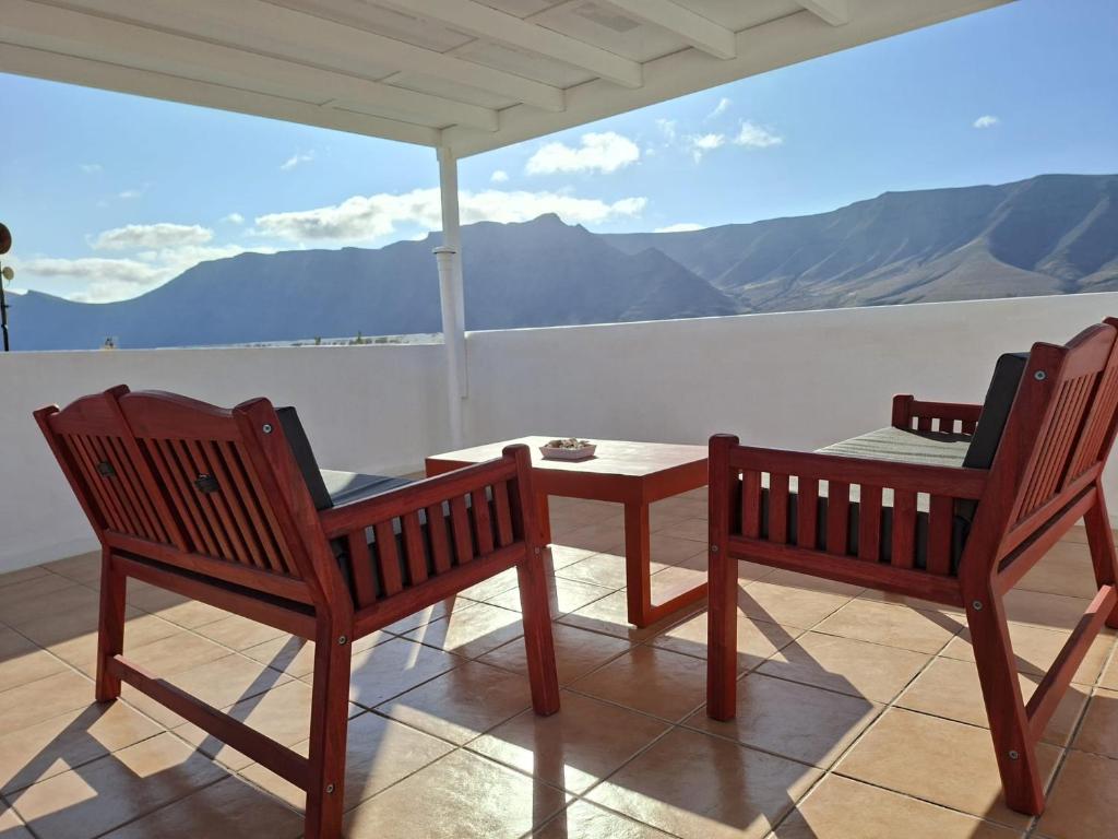 two chairs and a table on a balcony with a view at Dunas de Famara in Famara
