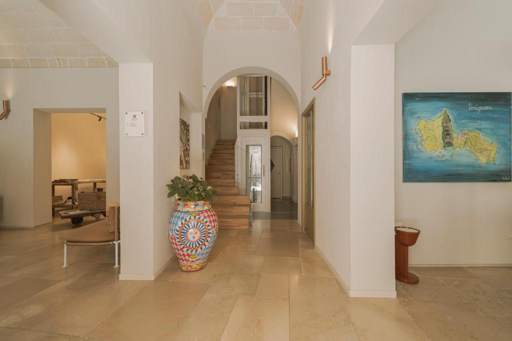 a hallway with a vase in the middle of a room at Albergo Egadi in Favignana