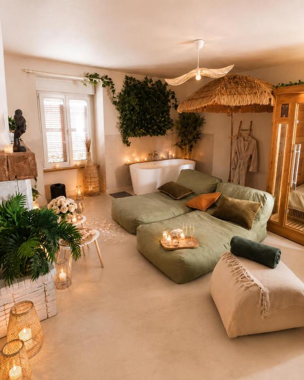 a living room with a couch and a table at Suite Climatisé Bali SPA et sauna privé pour 2-Châteaux de la Loire in Cour-Cheverny