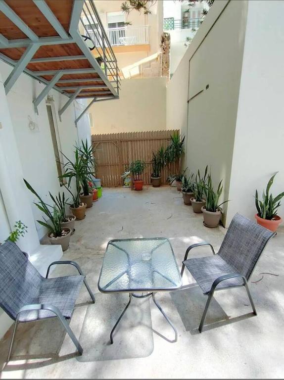 two chairs and a glass table in a courtyard at Zachos studio in Heraklio