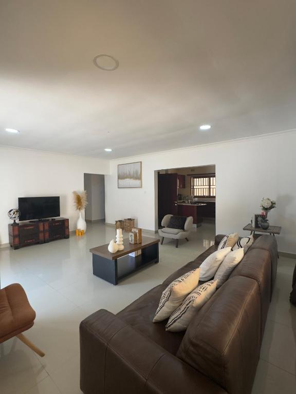 a living room with a brown couch and a table at JAYNIEL Apartments #2 in Lusaka