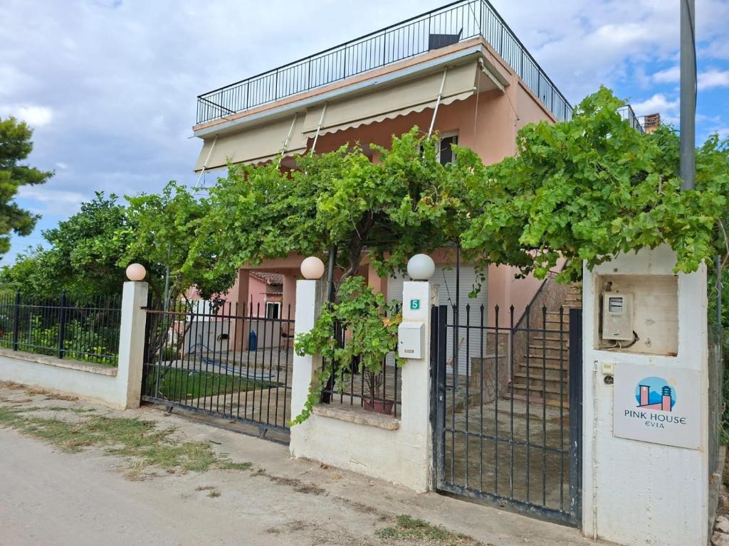 a house with a fence and vines at Pink House Eretria in Eretria