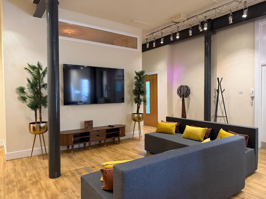 a living room with a blue couch and a tv at The Holyrood Mega-Quarters in Edinburgh