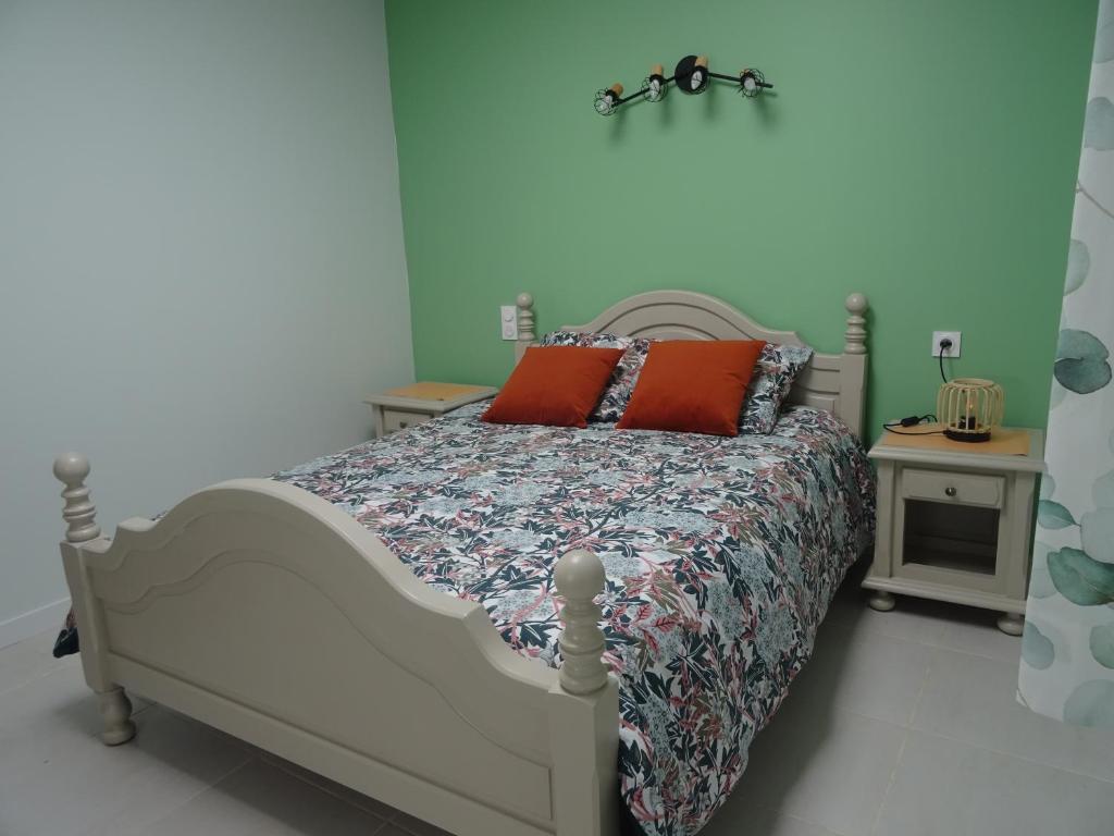 a bedroom with a bed with red pillows on it at Chambre Jasmin in Maubec