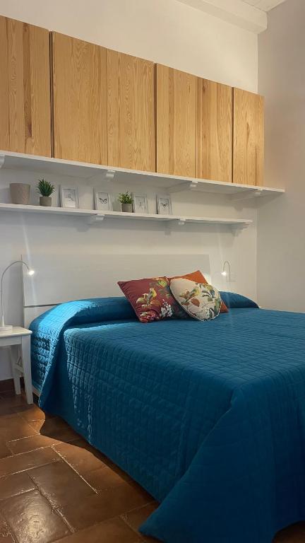 a bedroom with a blue bed and wooden cabinets at Al numero 15 in Castel Gandolfo