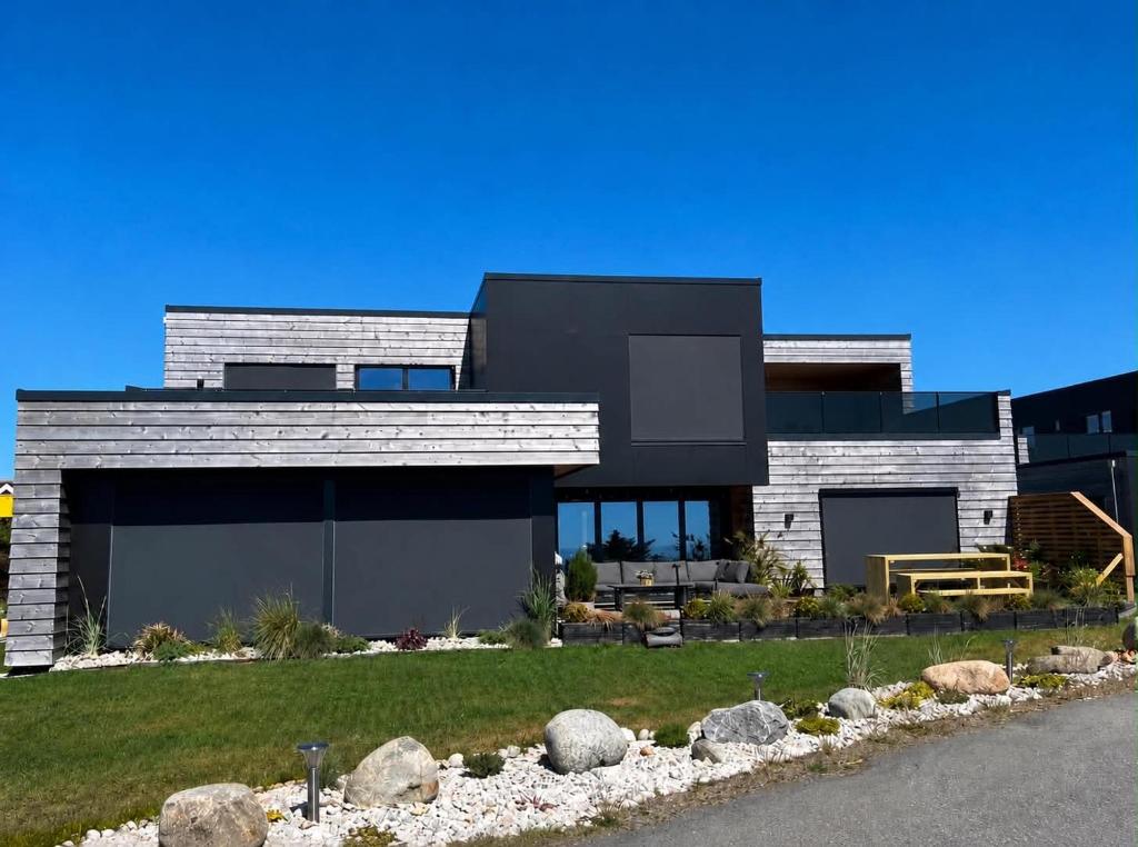 a modern house with a black at Bausje Beach House in Farsund