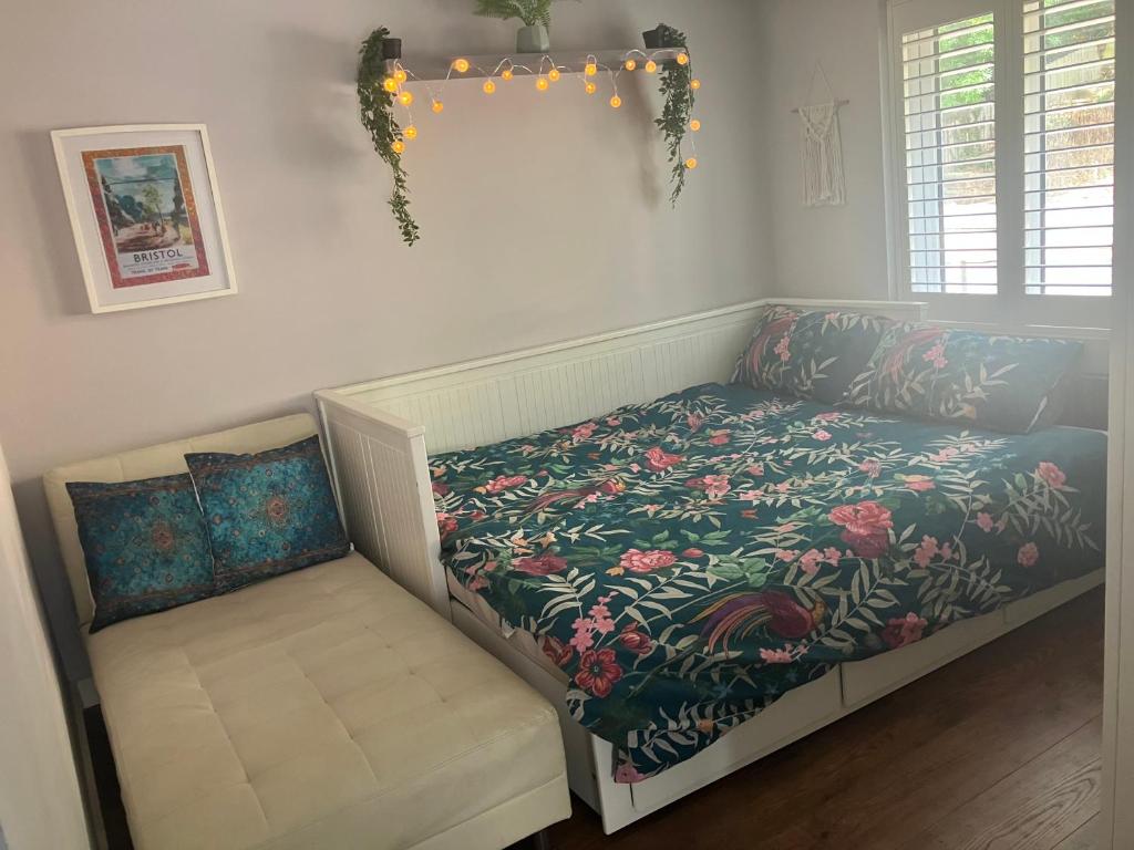 a bed with a floral comforter in a bedroom at Ilsyn Grove in Brislington