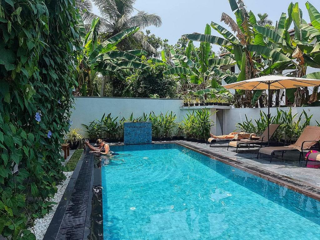 a man is in a swimming pool in a house at Villa White Elephant in Hikkaduwa