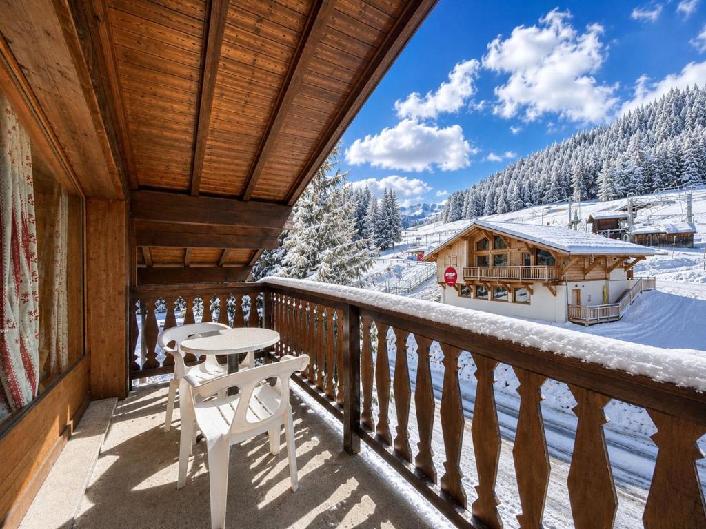 a balcony of a cabin with a table and chairs at Chaleureux appartement au pied des pistes avec parking et animaux admis - FR-1-505-65 in Notre-Dame-de-Bellecombe
