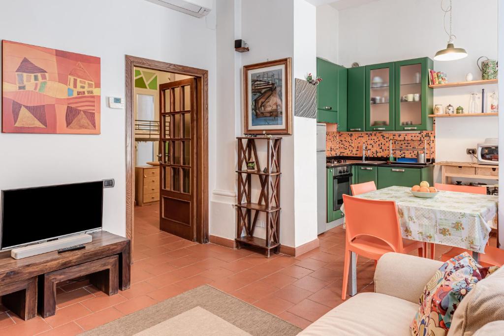 a living room with a tv and a table at Garden House Firenze - Careggi Meyer - Tramvia - 10 min dal Centro - Parcheggio vicinanze in Florence