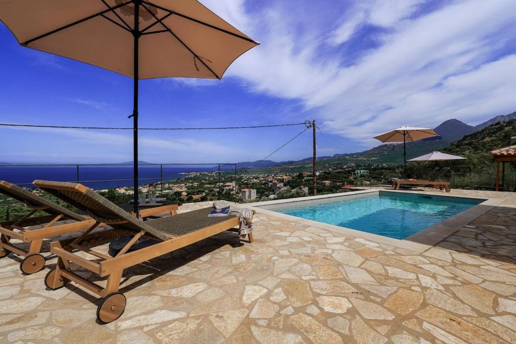 a swimming pool with a chair and an umbrella at Villa Thea with Pool & panoramic Sea View in Kotrónion