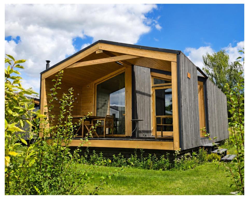 ein winziges Haus mit einem großen Fenster auf einem Feld in der Unterkunft 308-Tiny House Inn in Bleckede