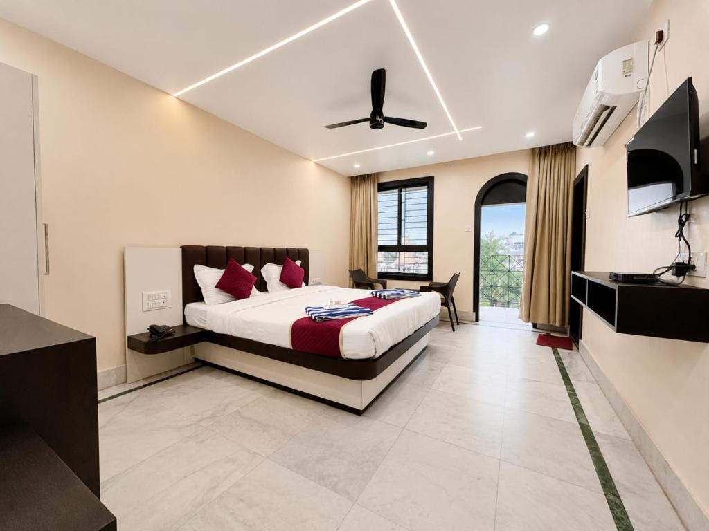 a bedroom with a king sized bed and a television at The Binapani Hotel And Restaurant in Tarapith