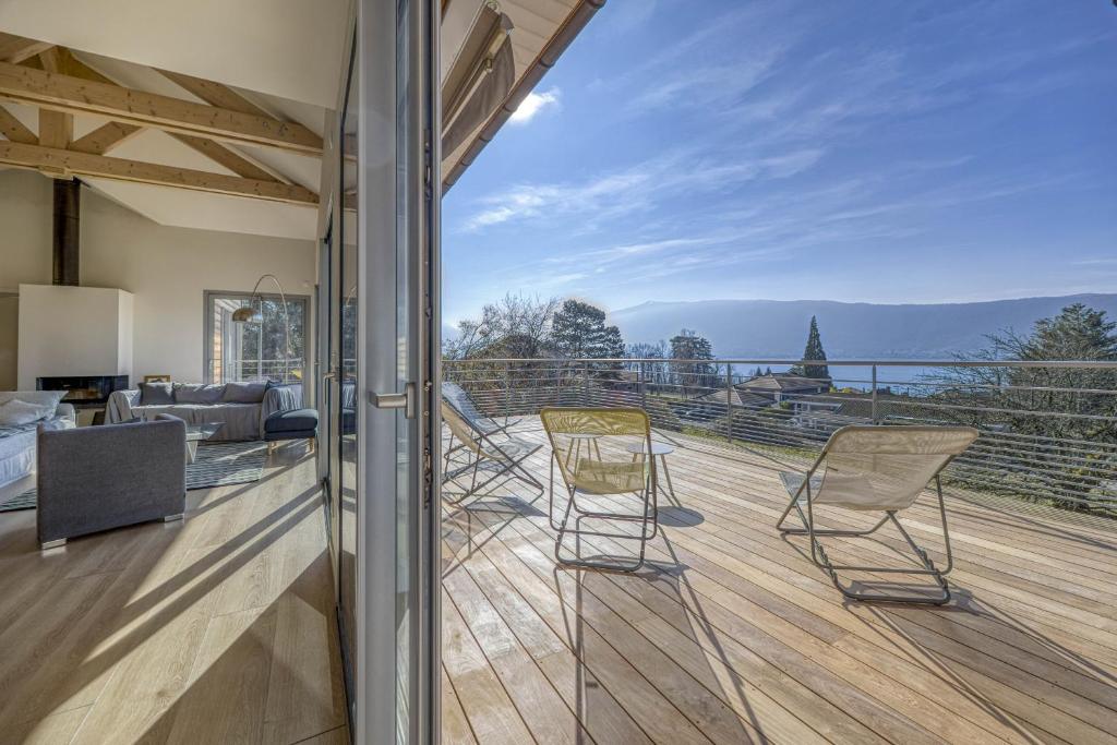 a balcony with chairs and a view of the mountains at Wooden Villa 4 in Veyrier-du-Lac