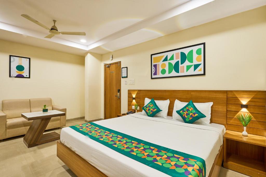 a bedroom with a bed and a chair and a table at Treebo Landmark in Visakhapatnam
