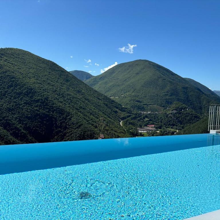 a infinity pool with mountains in the background at Hotel Panorama in Cerreto di Spoleto