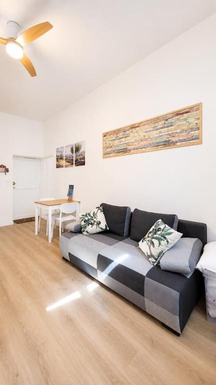 a couch in a living room with a ceiling fan at Escapade Provencale in Lectoure