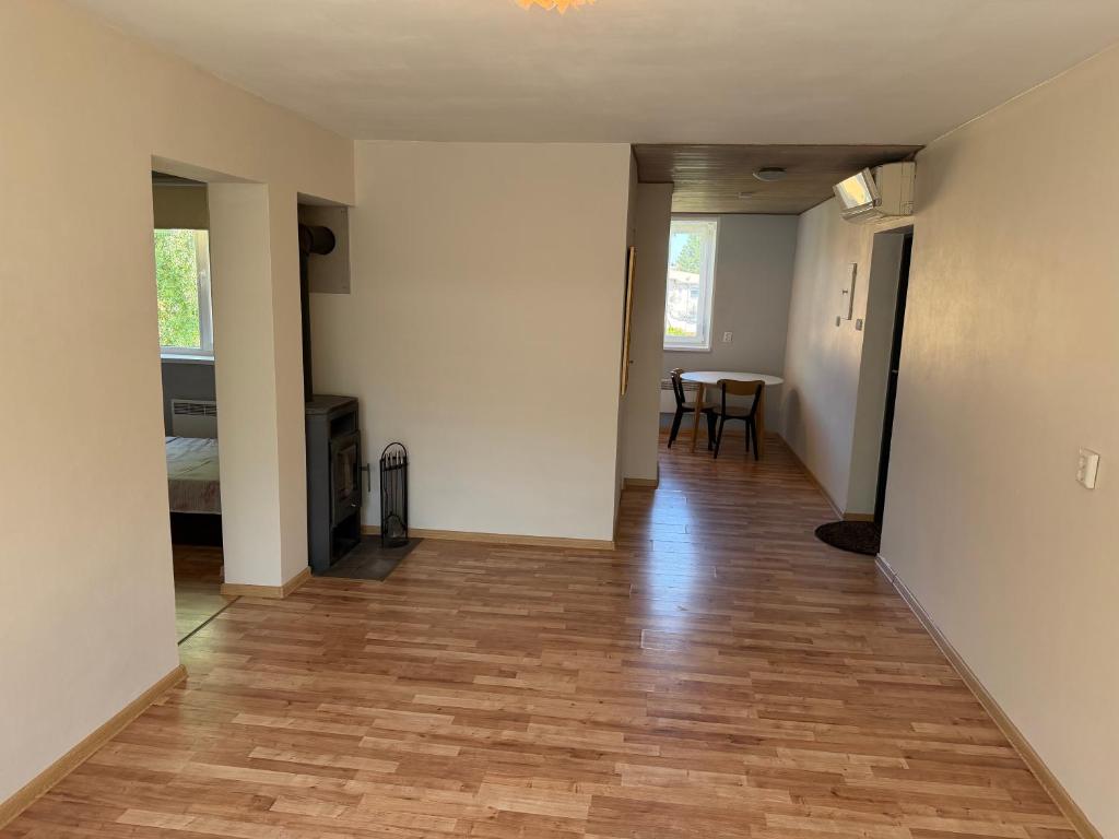 an empty living room with a wooden floor and a table at 40m2 apartmnet in Viljandi