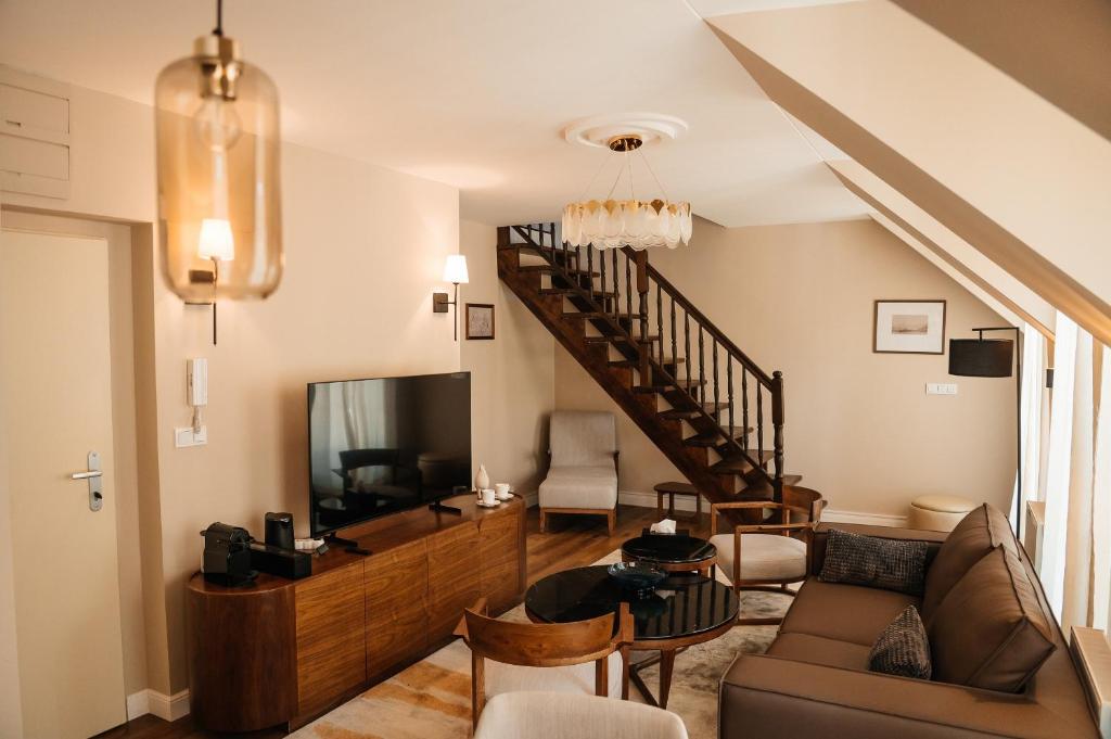 a living room with a couch and a tv at Castle Hill Residence in Karlovy Vary