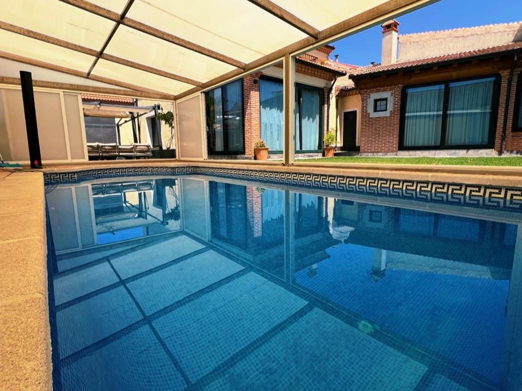 a swimming pool in front of a house at La Villa de Pi in Garcillán