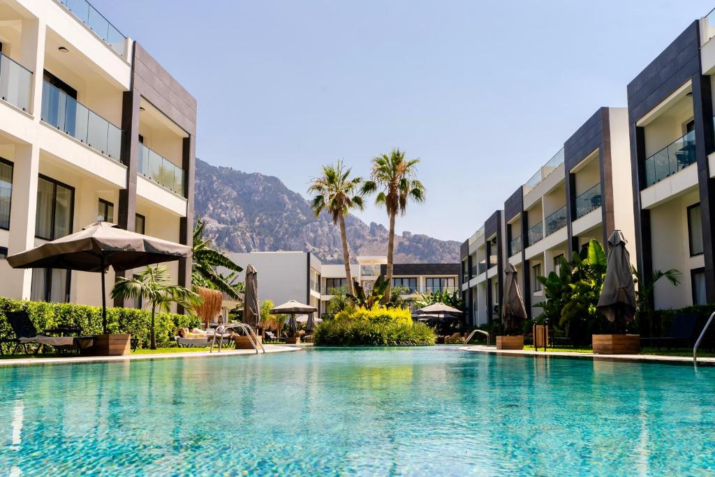 a swimming pool in the middle of a hotel at Palmera Resort Wellness & Spa - Mountain & Pool View Studio 1 by Azur Prime in Vasilia
