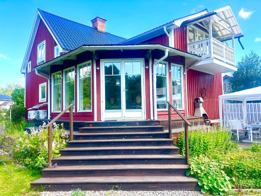 a red house with stairs in front of it at Scandinavian Villa near Sea with Sauna 4BR in Söderhamn