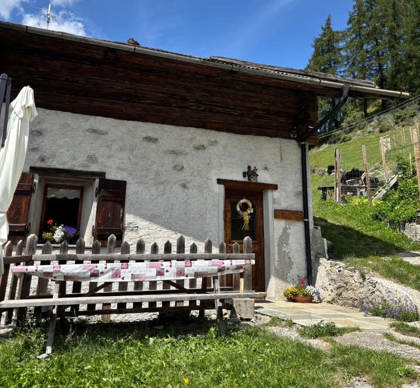 a church with a bench in front of a building at Chalet di Mont in Valfurva