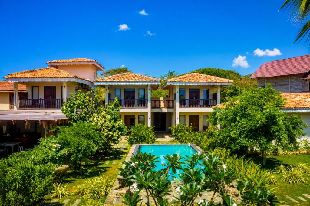 an exterior view of a villa with a swimming pool at Guru Beach Resort in Tangalle