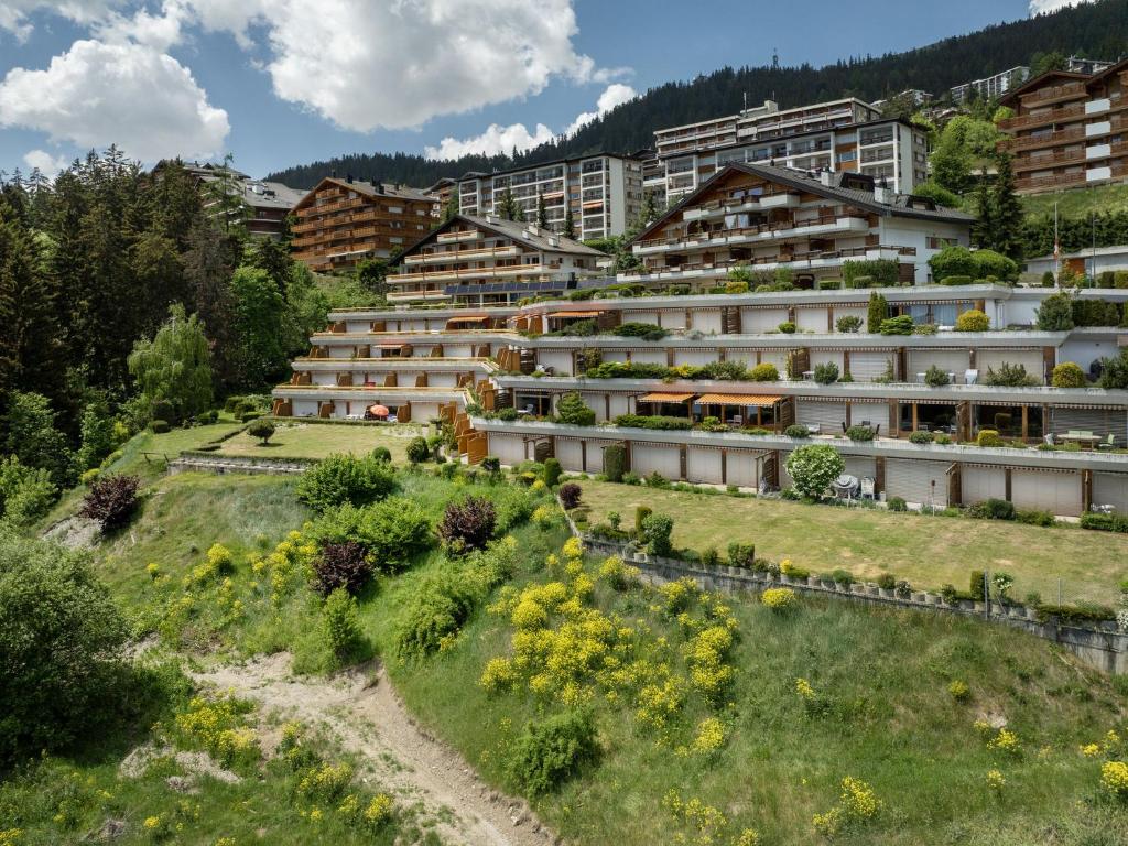 an apartment building with a garden on a hill at Apartment Terrasse Des Alpes 814 by Interhome in Vermala